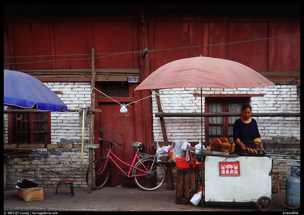 Foot stand in front of a wooden building. Kunming, Yunnan, China