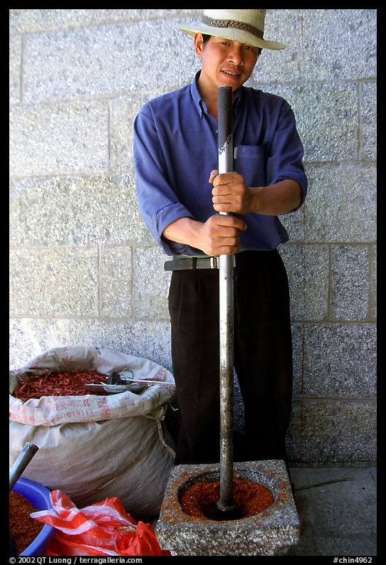 Spice vendor crushing red pepper. Dali, Yunnan, China