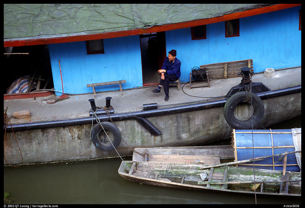 Man sitting on a house boat. Leshan, Sichuan, China