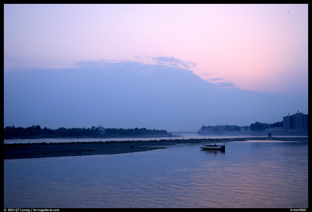 Boat at the confluence of the Dadu He and Min He rivers at sunset. Leshan, Sichuan, China