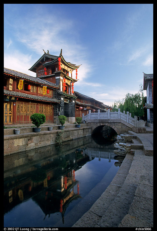 Kegong tower (memorial archway of imperial exam) reflected in canal, sunrise. Lijiang, Yunnan, China