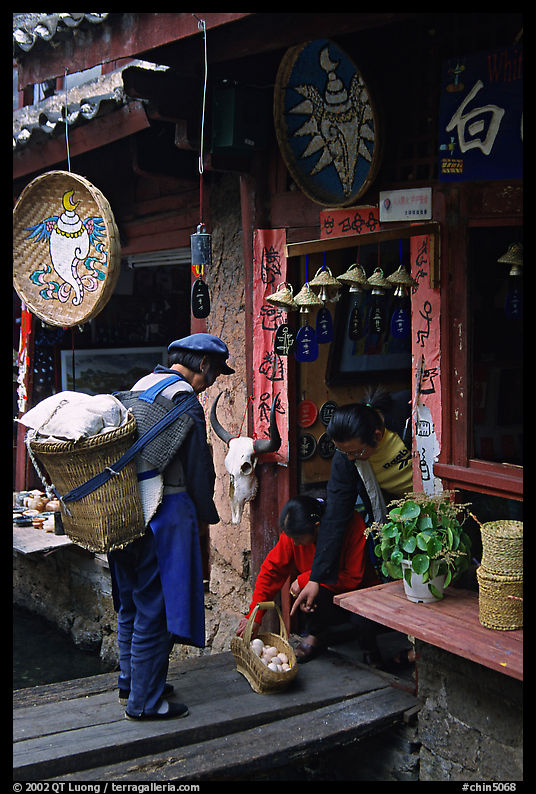 Naxi woman offers eggs for sale to local residents. Lijiang, Yunnan, China
