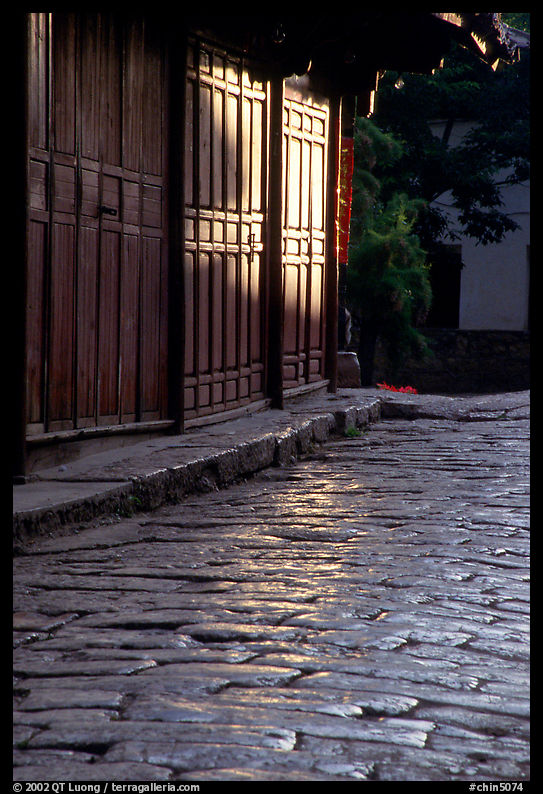 Cobblestone street and wooden doors at sunrise. Lijiang, Yunnan, China