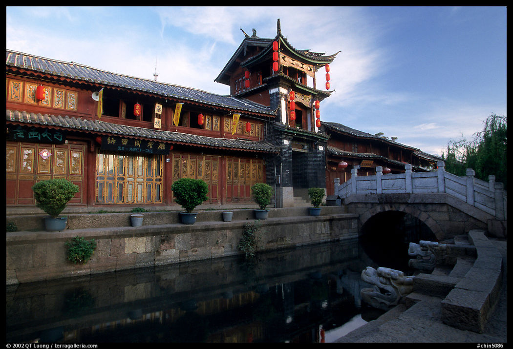 Kegong tower (memorial archway of imperial exam) reflected in canal, sunrise. Lijiang, Yunnan, China