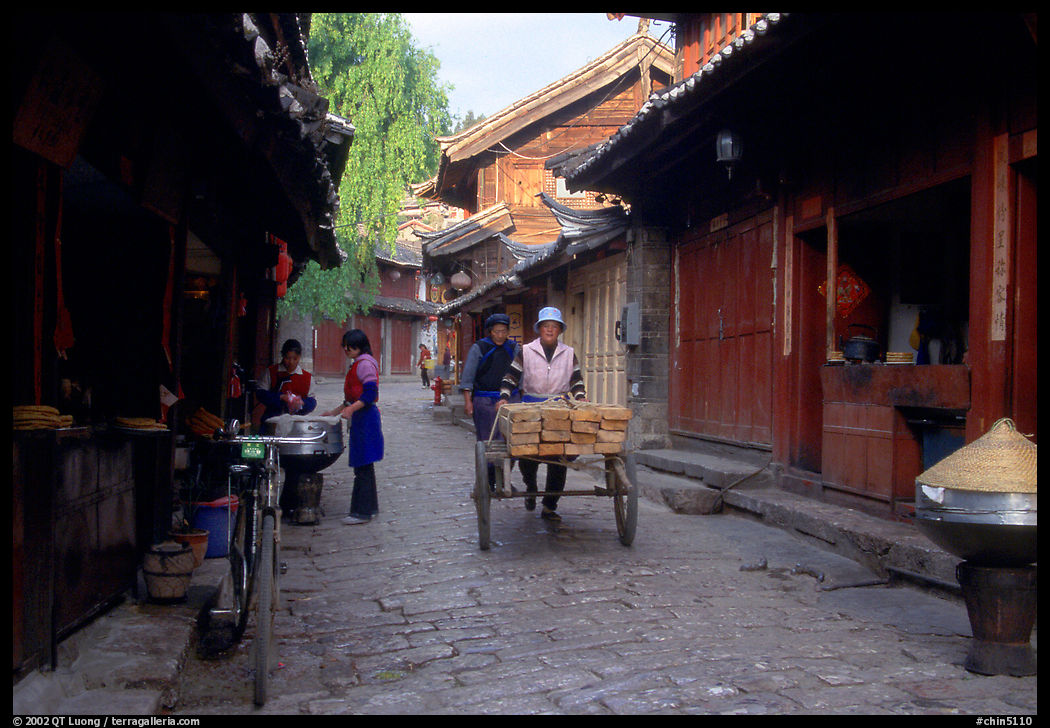 Early morning activity in a cobblestone street. Lijiang, Yunnan, China