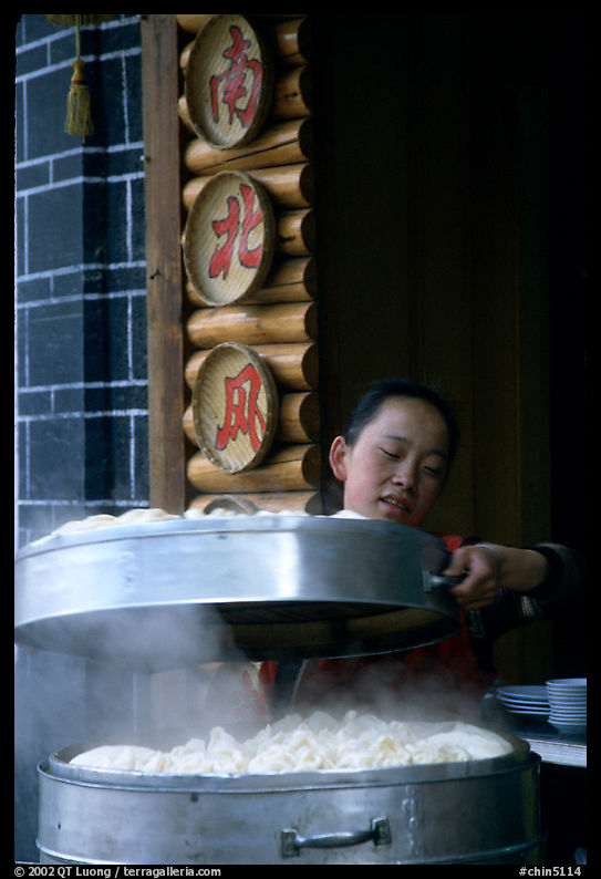 Woman baking dumplings. Lijiang, Yunnan, China
