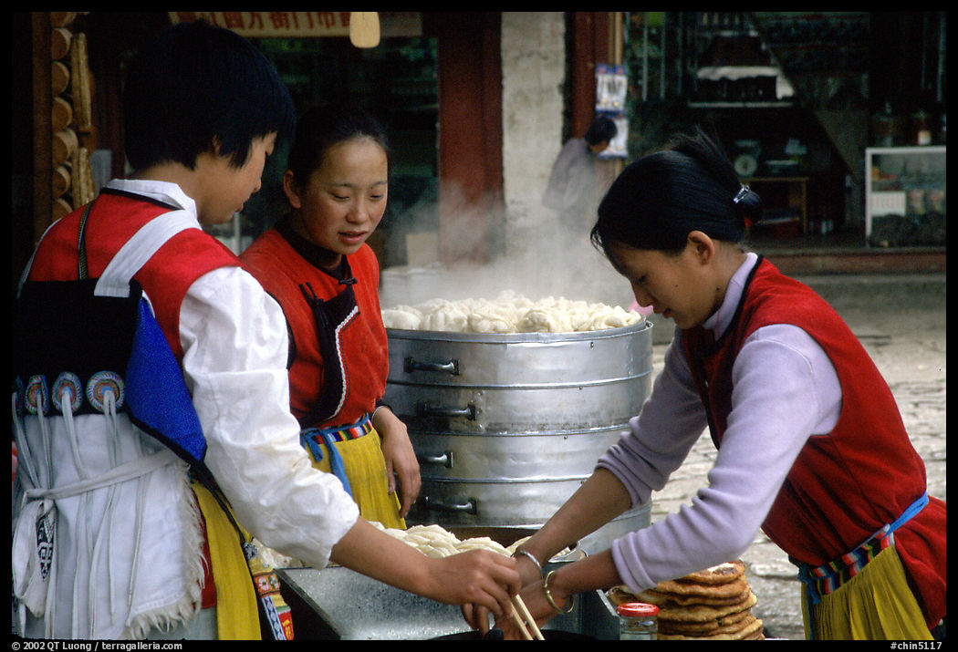 Naxi Women preparing the baba flatbreat. Lijiang, Yunnan, China
