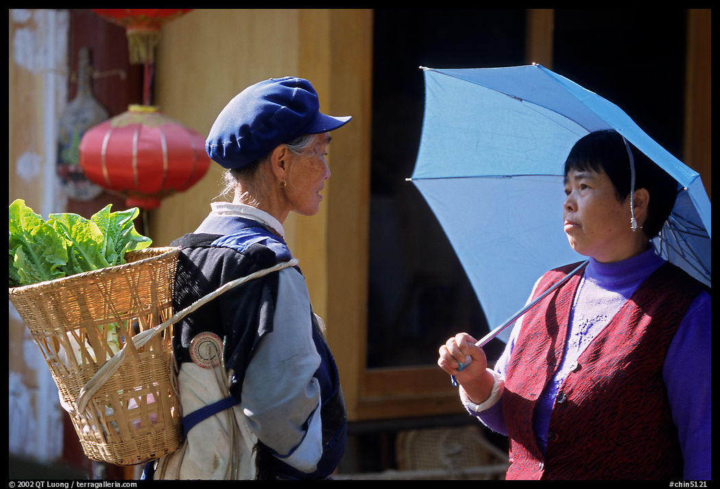 Two women conversing in the street. Lijiang, Yunnan, China