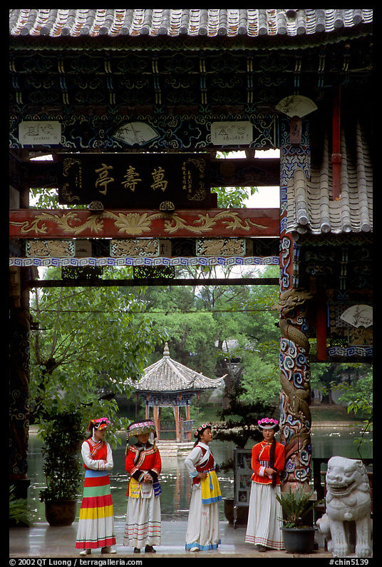 Women in Naxi dress standing in an archway. Lijiang, Yunnan, China