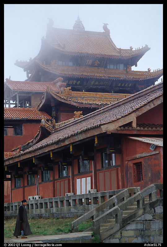 Monk beneath Jinding Si (Golden Summit) temple in the fog. Emei Shan, Sichuan, China