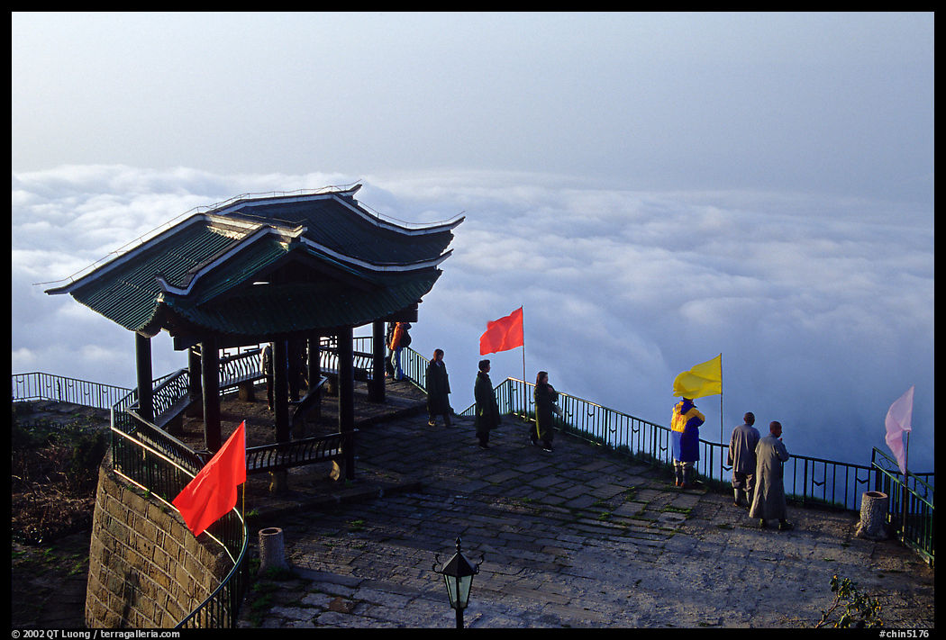 Monks and pilgrims admiring a sea of cloud from the summit. Emei Shan, Sichuan, China