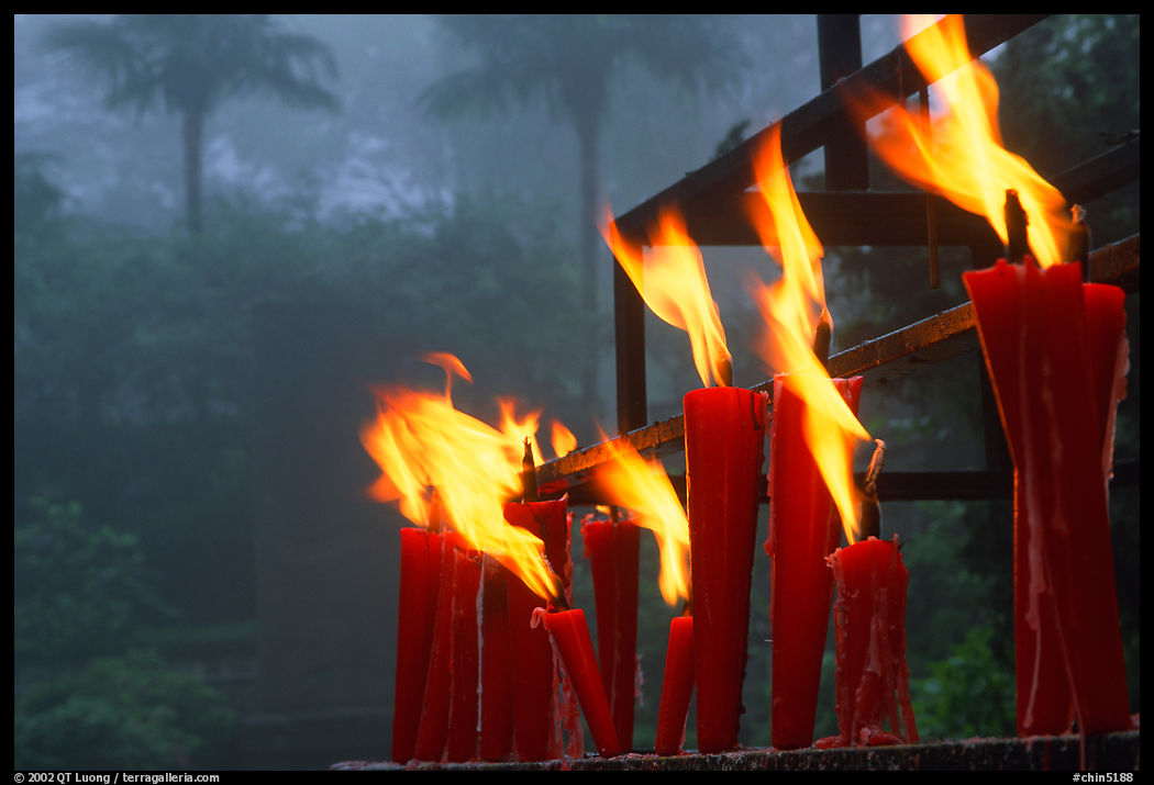Candles burning with foggy trees in the background, Wannian Si. Emei Shan, Sichuan, China