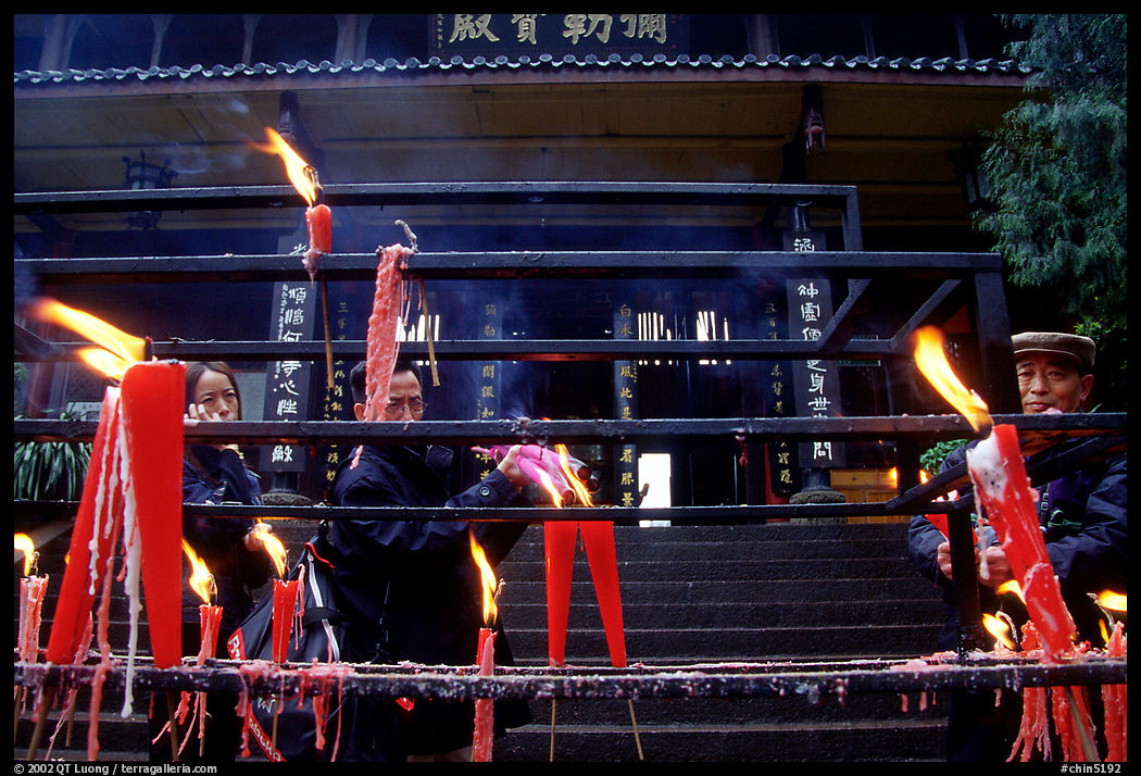 Pilgrims lighting incense sticks with Wannian Si temple in the background. Emei Shan, Sichuan, China