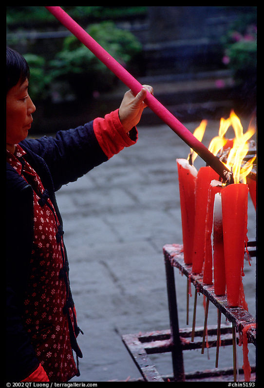 Woman Pilgrim lighting a large incense stick, Wannian Si. Emei Shan, Sichuan, China