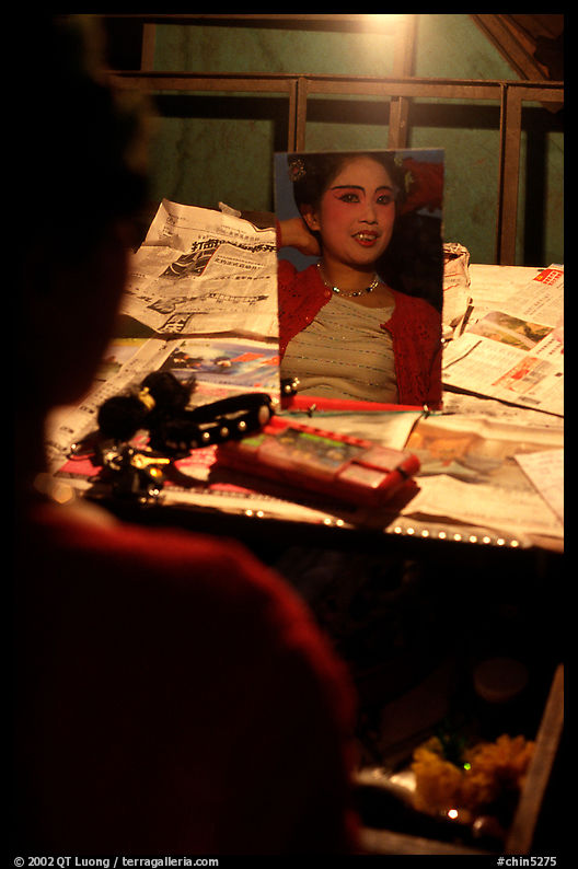 Sichuan opera actress checks her hair in a mirror. Chengdu, Sichuan, China
