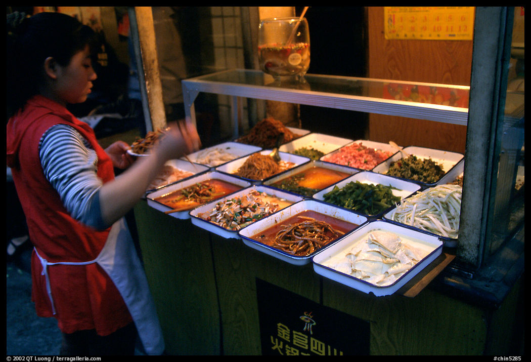 Woman helping herself to food. Sichuan food is among China's spiciest. Chengdu, Sichuan, China