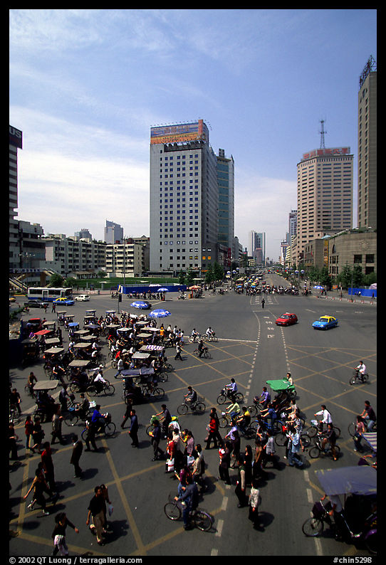 Pedestrians and bicyclists cross a major avenue. Chengdu, Sichuan, China