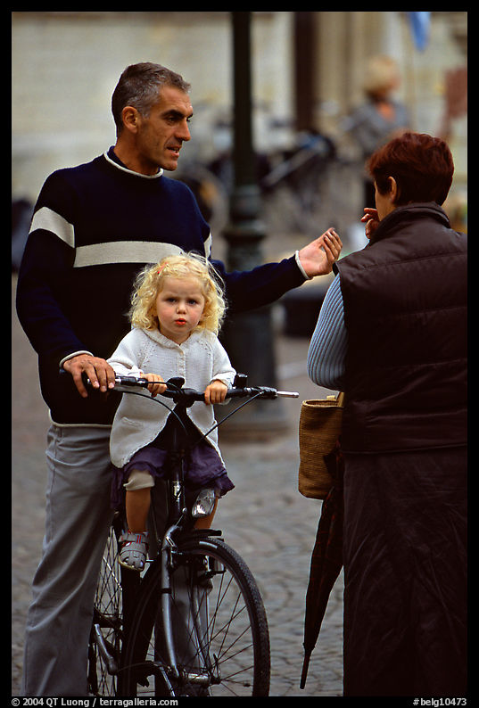 Blond little girl sitting on bicycle. Bruges, Belgium