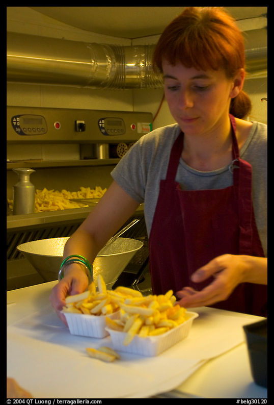 Woman serving fries in a booth. Bruges, Belgium