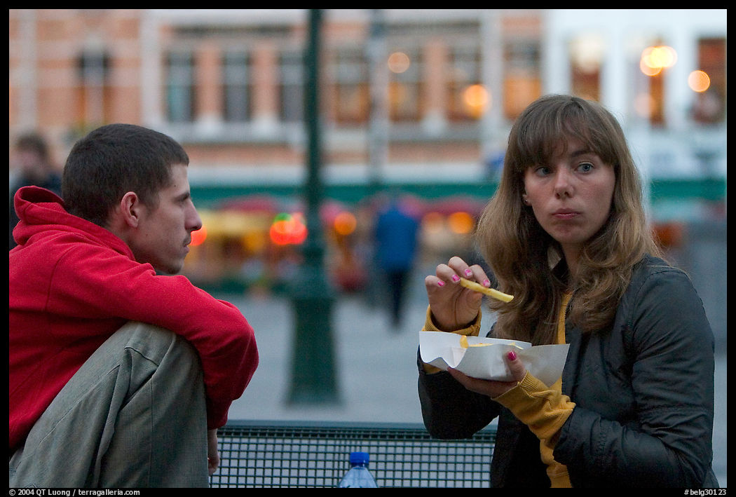 Young woman eating fries, Markt. Bruges, Belgium