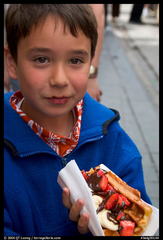 Boy eating a Belgian waffle. Brussels, Belgium