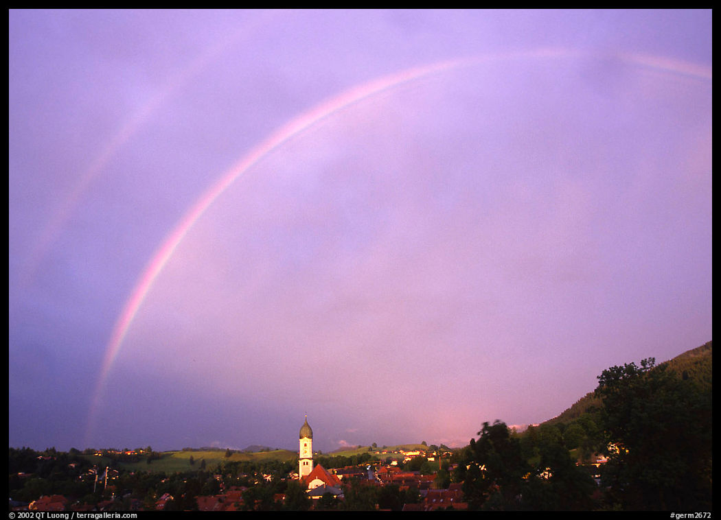 Rainbow over Nesselwang and St Andreas church. Bavaria, Germany