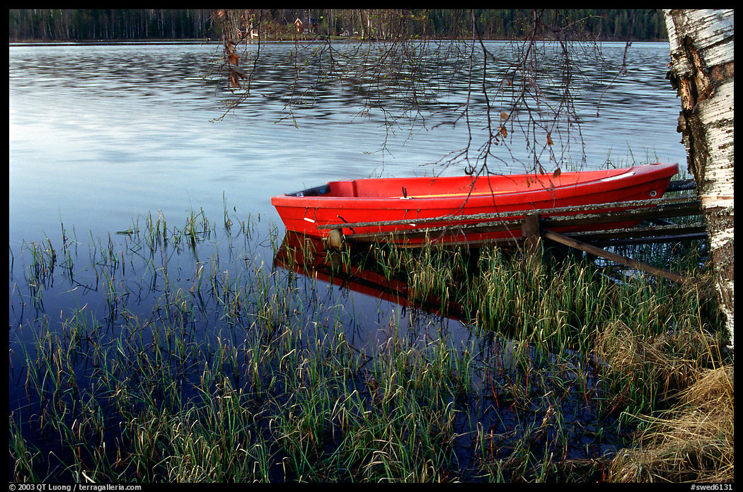 Red boat on a lakeshore. Central Sweden