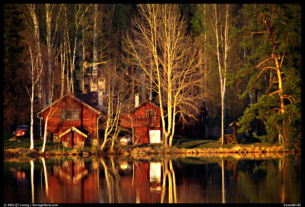 Wooden house reflected in a lake at sunset. Central Sweden