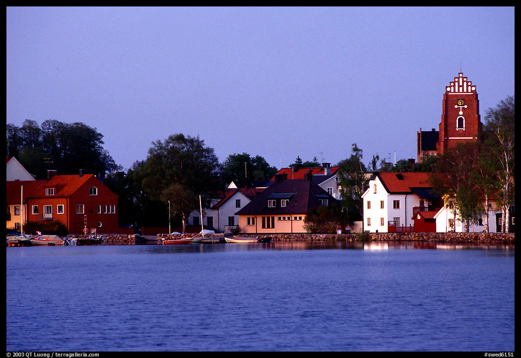 Houses, church, across the lake at dusk, Vadstena. Gotaland, Sweden