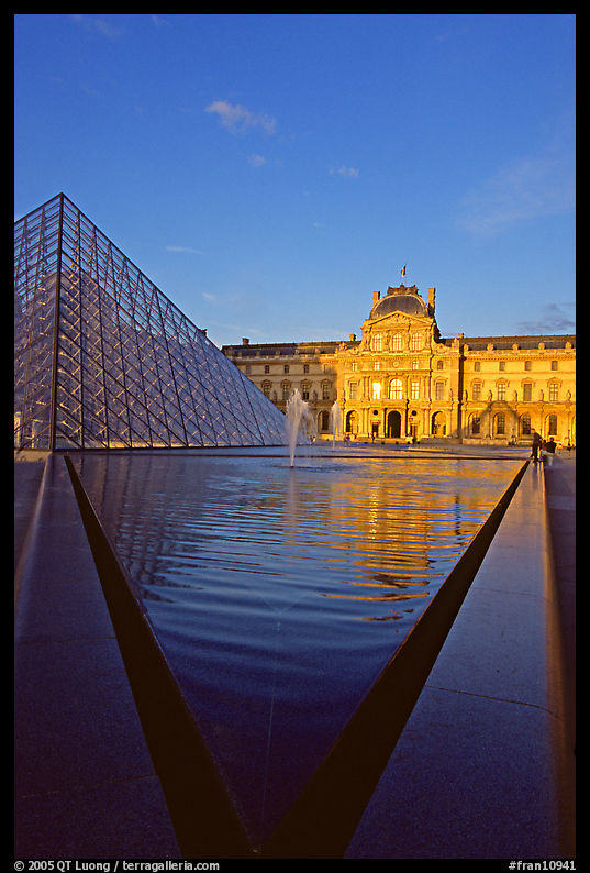 Pyramid and triangular basin in the Louvre, sunset. Paris, France