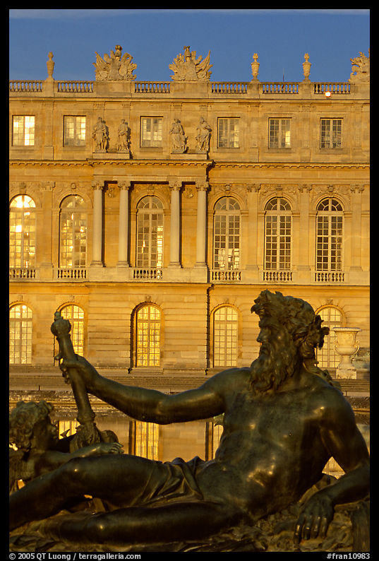 Statue, basin, and Versailles palace facade, late afternoon. France