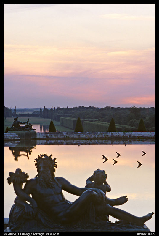 Sculptures, basin, and gardens at dusk, Versailles Palace. France