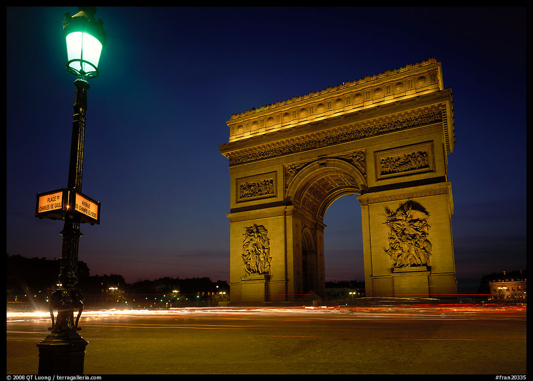 Street lamp and Etoile triumphal arch at night. Paris, France