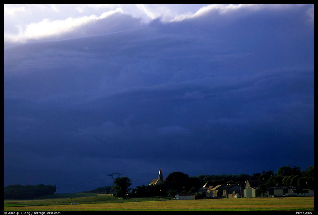 Stormy skies and village. France