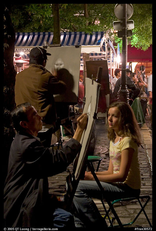 Artists drawing portraits at night on the Place du Tertre, Montmartre. Paris, France