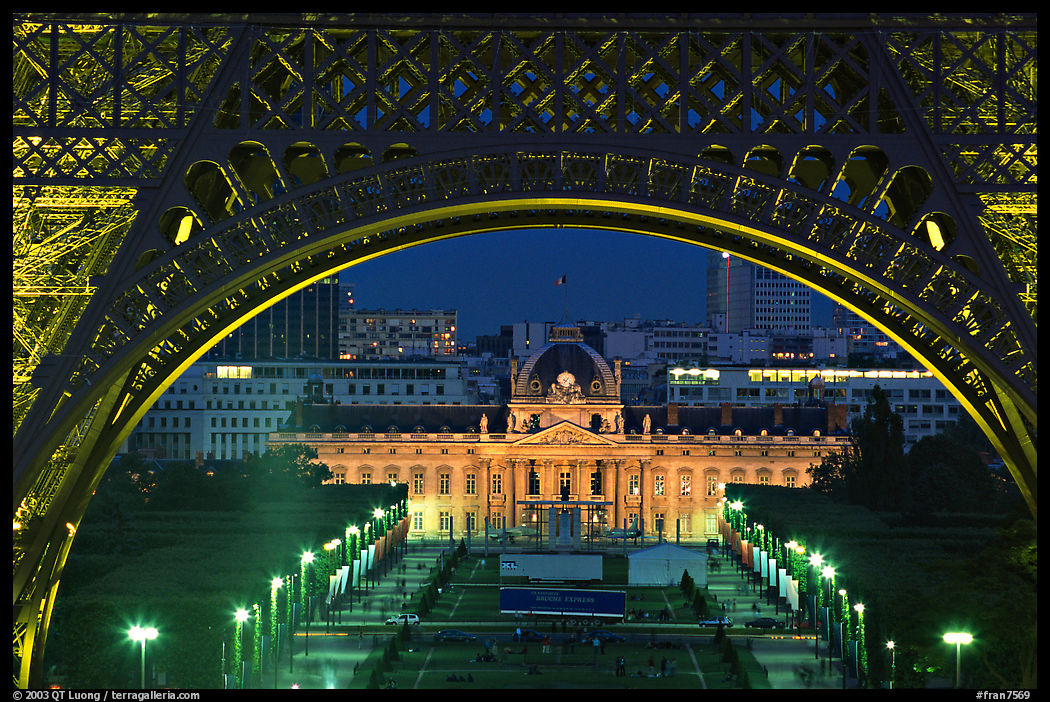 Ecole Militaire (Military Academy) seen through Eiffel Tower at night. Paris, France