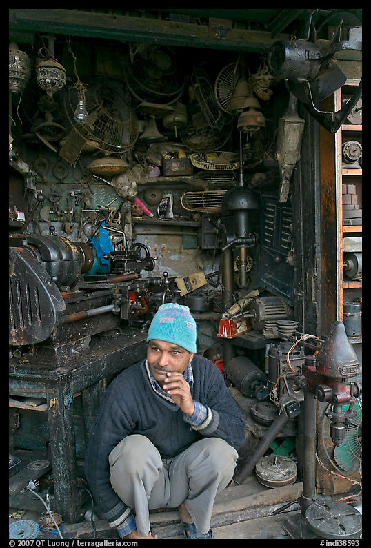 Man sitting in front of machine parts shop, Old Delhi. New Delhi, India