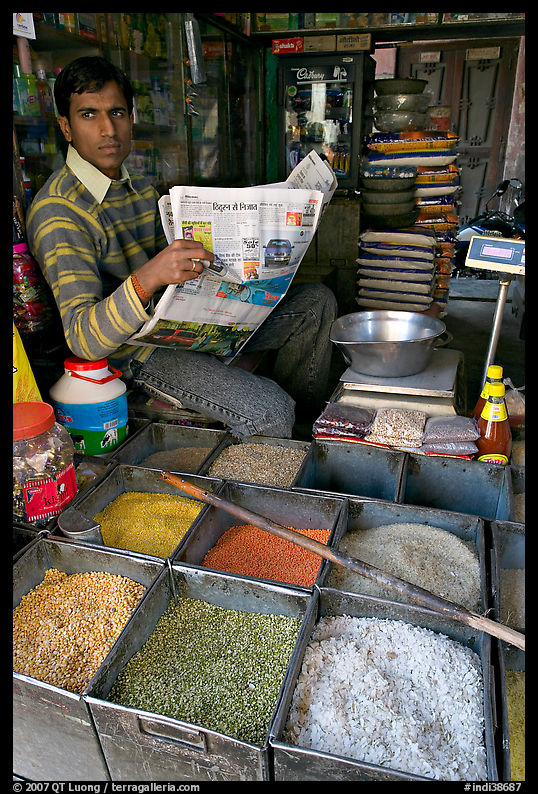 Man with newspaper selling grains, Sardar Market. Jodhpur, Rajasthan, India