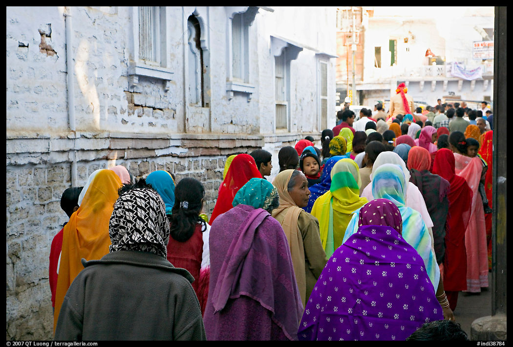 Women in colorful sari walking a  narrow street during wedding. Jodhpur, Rajasthan, India