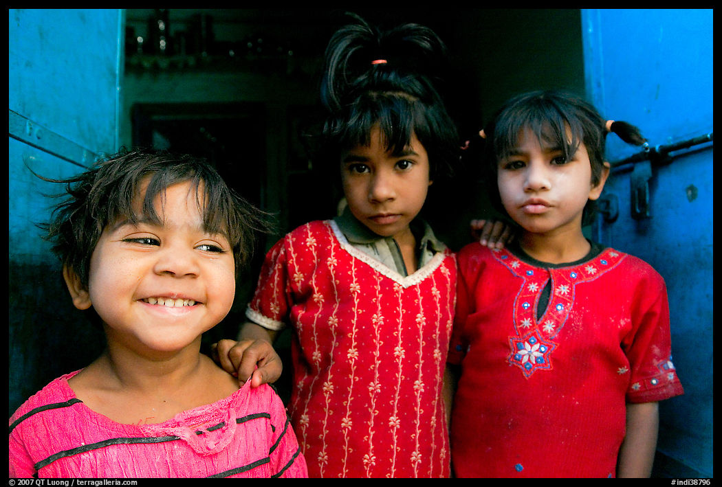 Girls in red dress and blue doors. Jodhpur, Rajasthan, India