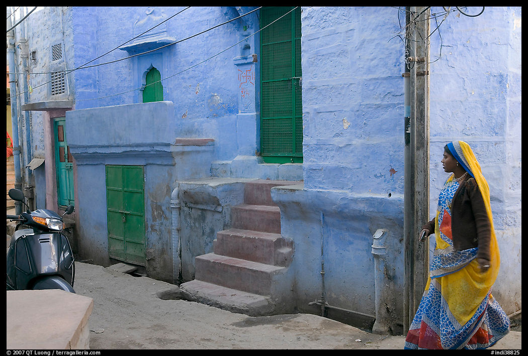 Woman walking in narrow street with blue walls. Jodhpur, Rajasthan, India
