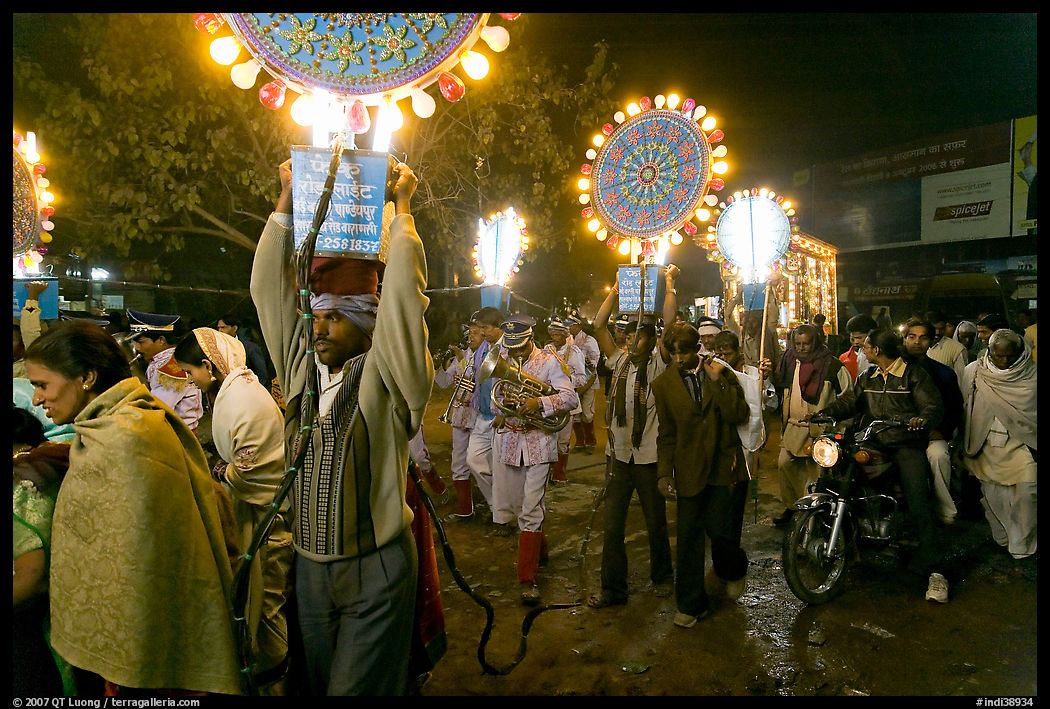 Men carrying bright electric signs during wedding procession. Varanasi, Uttar Pradesh, India