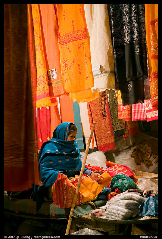 Woman selling fabrics at night. Varanasi, Uttar Pradesh, India