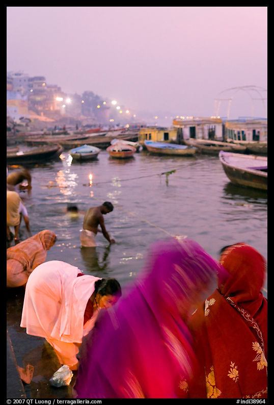 Women on the banks of the Ganga River in rosy dawn light. Varanasi, Uttar Pradesh, India