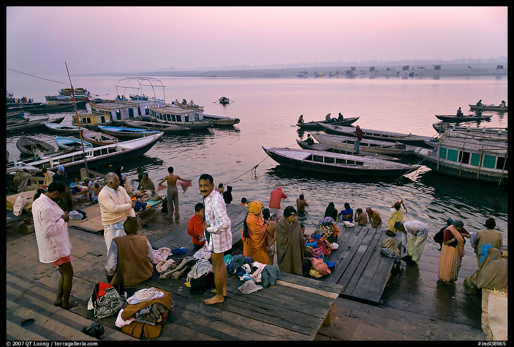 Men preparing for ritual bath on banks of Ganges River at dawn. Varanasi, Uttar Pradesh, India