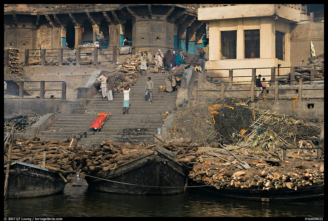 Steps of Manikarnika Ghat with body swathed in cloth and firewood piles. Varanasi, Uttar Pradesh, India