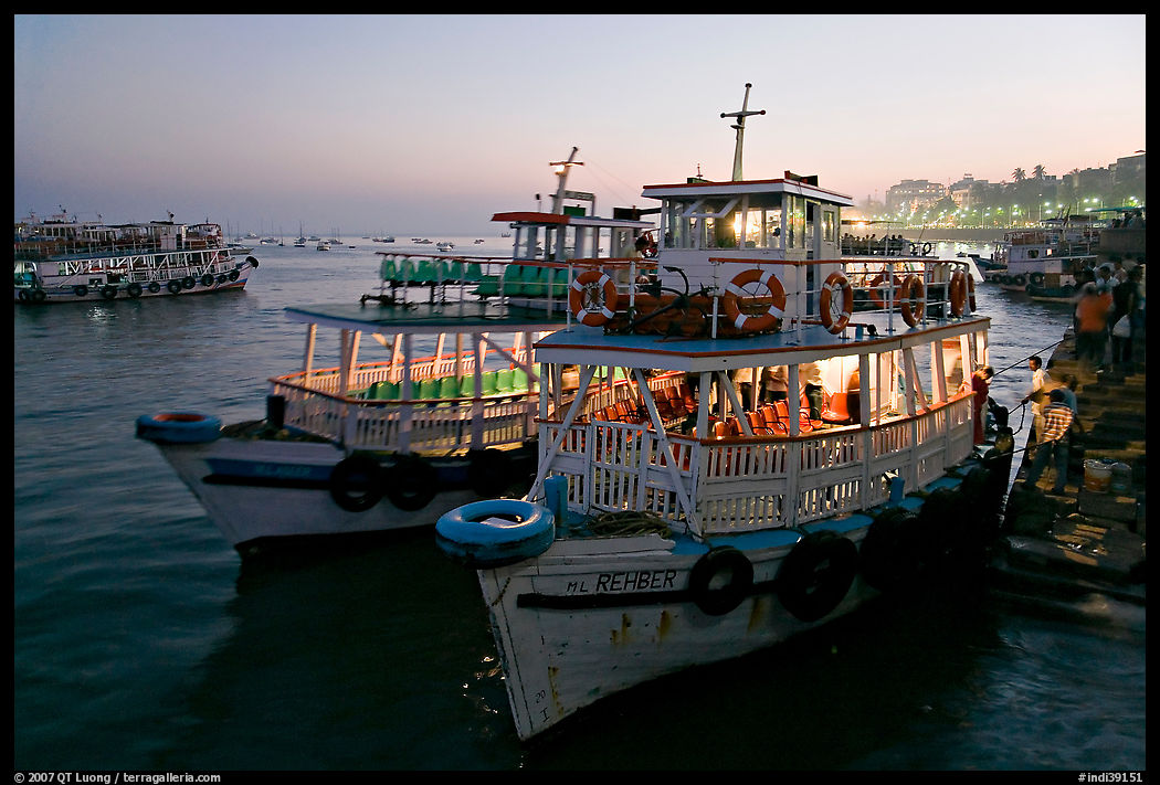 Lighted tour boat at quay,  sunset. Mumbai, Maharashtra, India