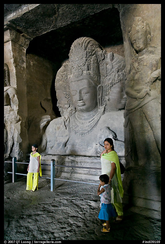 Woman and children standing in front of Mahesh Murti, main  Elephanta cave. Mumbai, Maharashtra, India