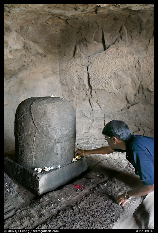 Man venerating a Linga in Shiva shrine, Elephanta Island. Mumbai, Maharashtra, India