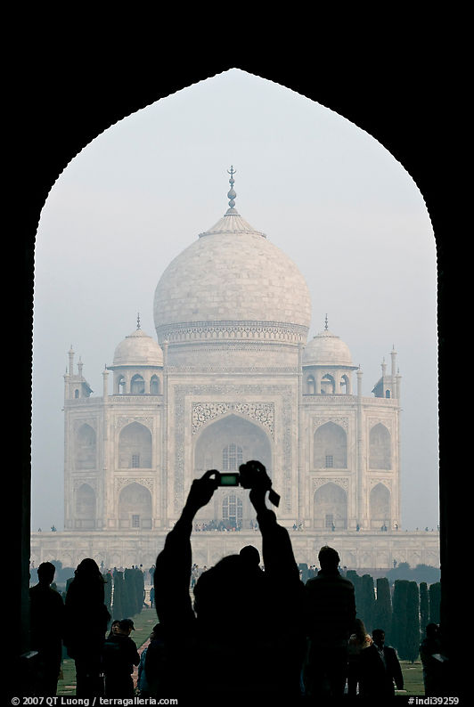 Visitor pointing  digital camera to Maj Mahal, framed by arch of gateway. Agra, Uttar Pradesh, India